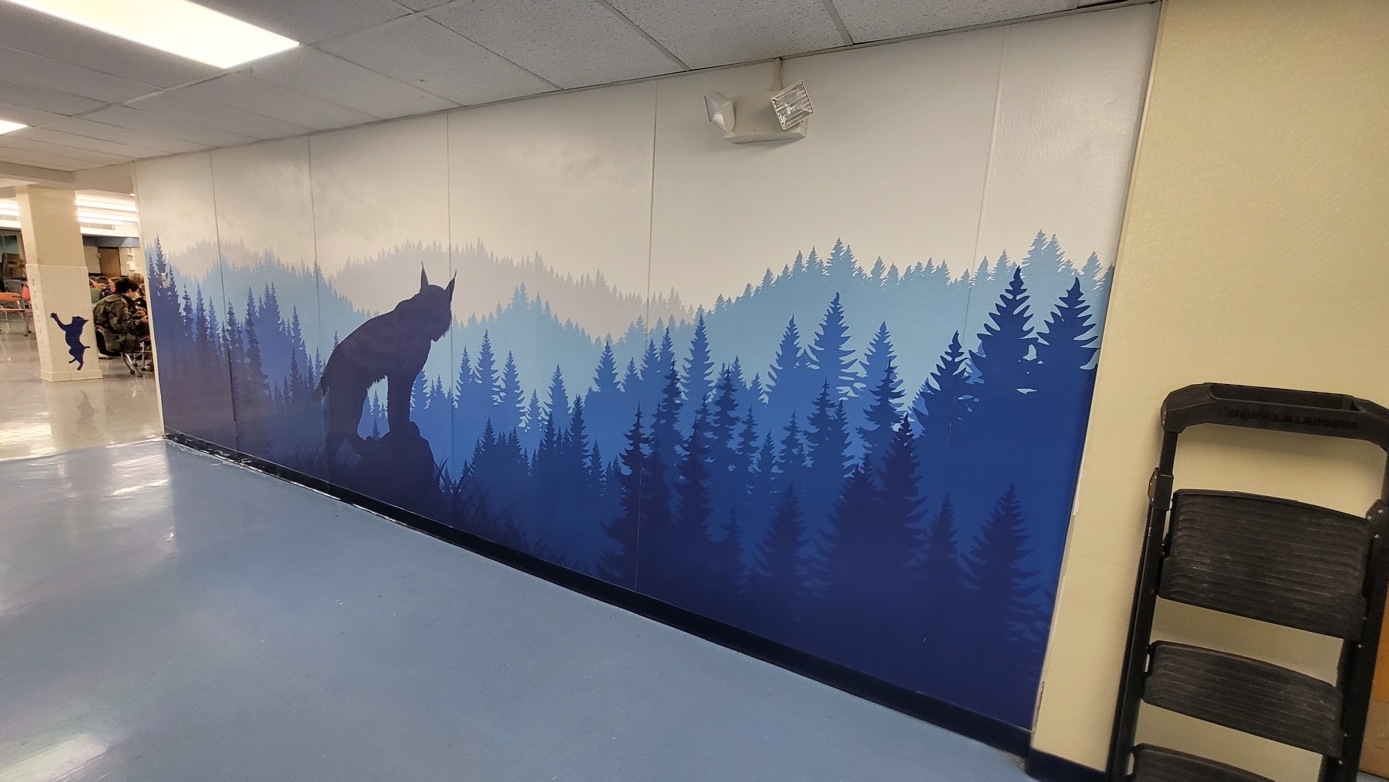 Large wall vinyl graphic featuring a bobcat looking over trees