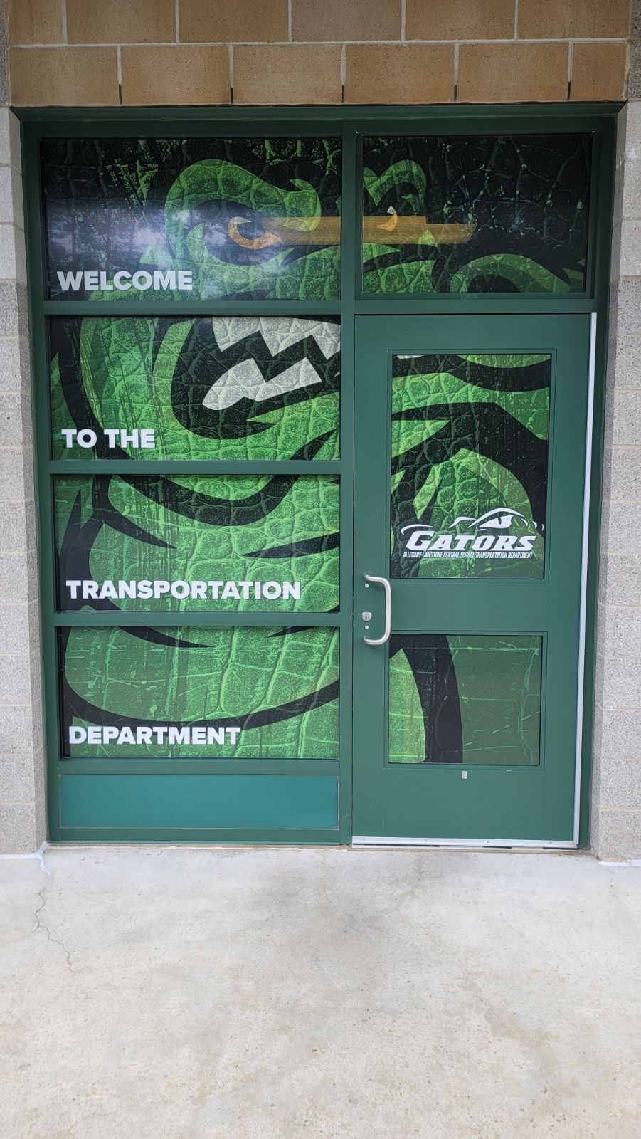 Vinyl door wrap featuring ALCS Gator Logo with text saying Welcome to the Transportation Department