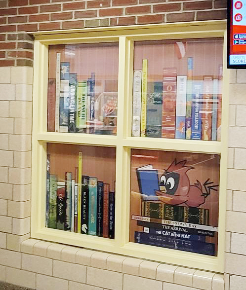 Window graphics depicting a cartoon cardinal reading books.