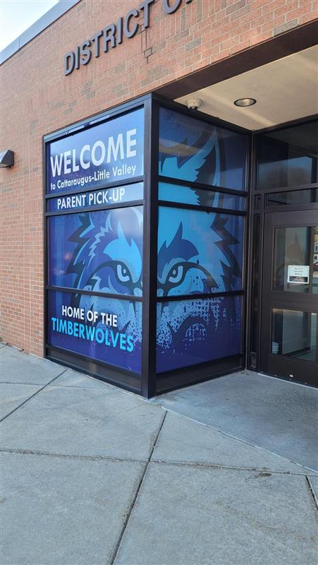 Installed graphic at Cattaraugus-Little Valley High School with school colors, a wolf face and text saying "Home of the Timberwolves" for the parent pickup area.