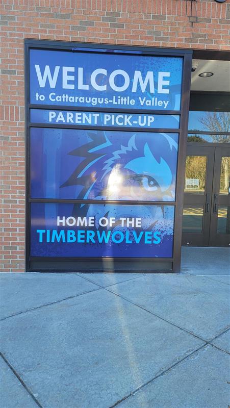 Installed graphic at Cattaraugus-Little Valley High School with school colors, a wolf face and text saying "Home of the Timberwolves" for the parent pickup area.